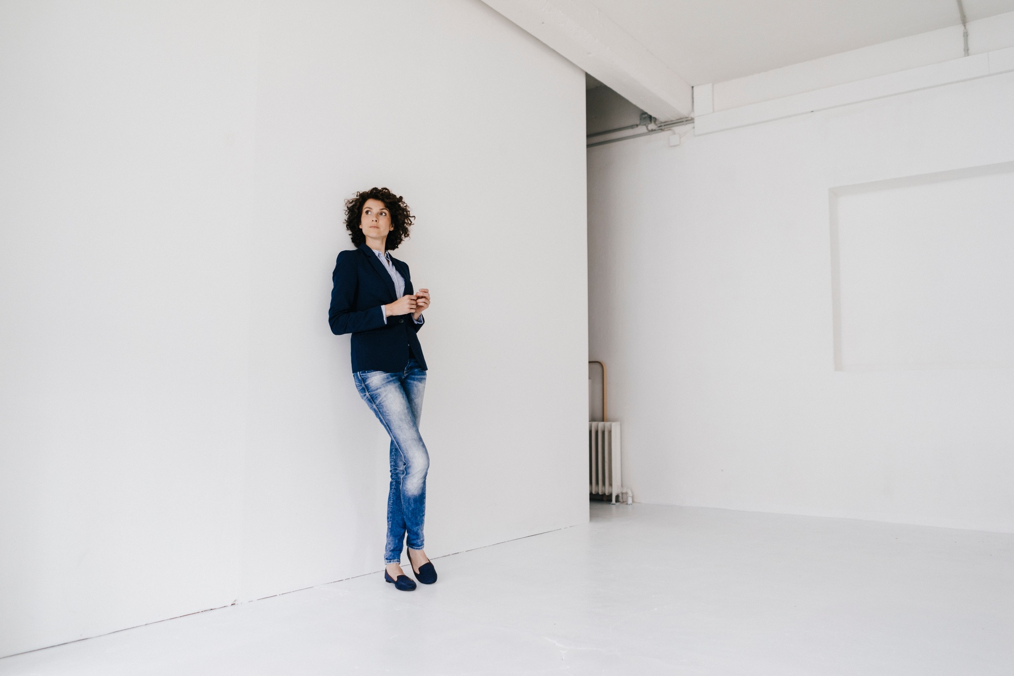 Businesswoman standing in loft , leaning against wall Businesswoman standing in loft , leaning against wall